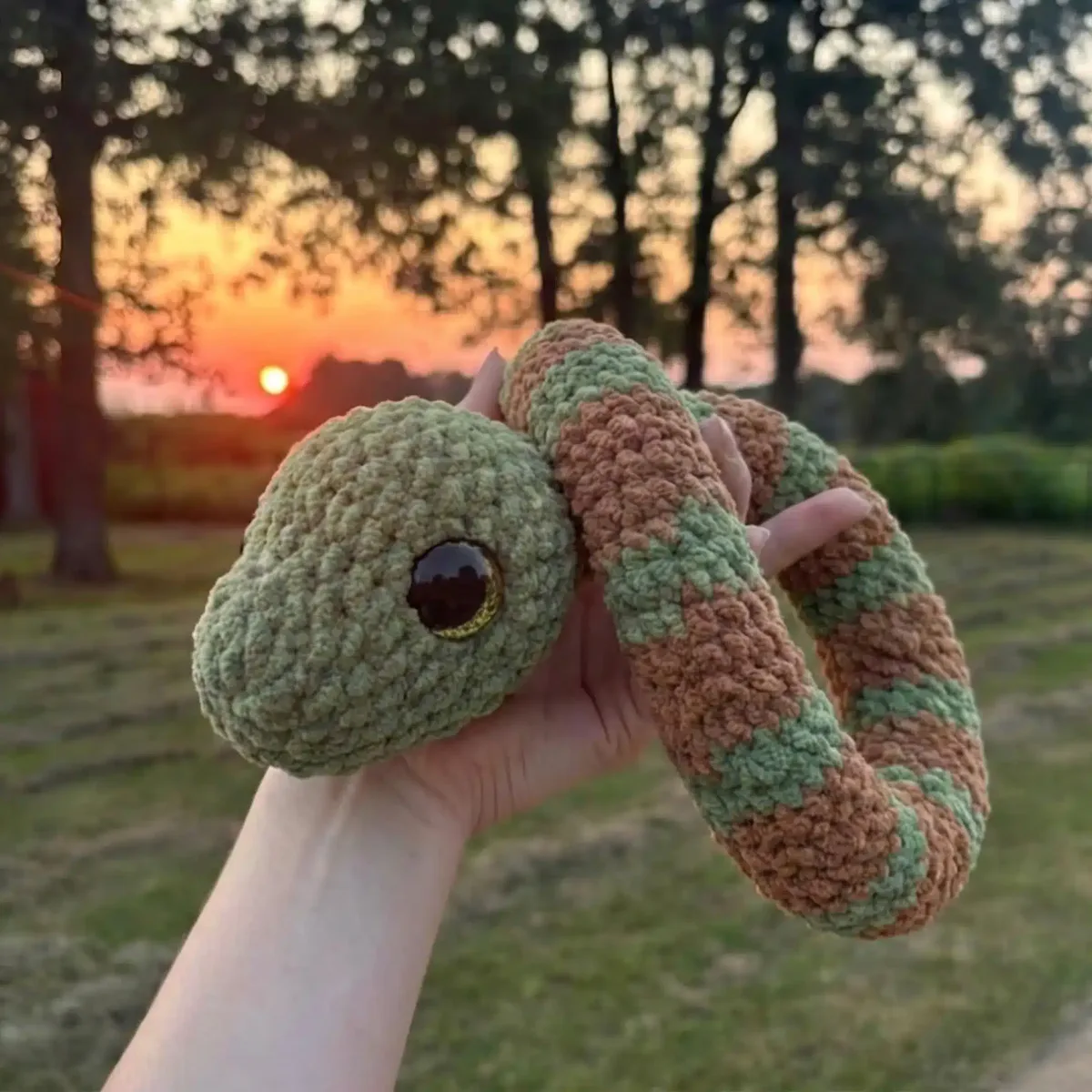 Crochet snake amigurumi with coral colourwork bands
